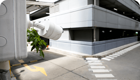 image (33) CCTV camera mounted in a commercial setting, monitoring a parking area with clear visibility of the building and surrounding environment, emphasizing security solutions for businesses in Perth.